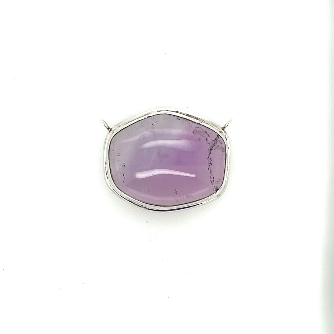 Clear amethyst cabochon with solid sterling silver bezel. Sterling is Blackard, so should not tarnish.